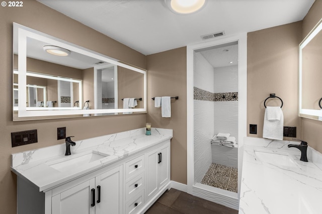 bathroom featuring a tile shower, tile floors, and double sink vanity