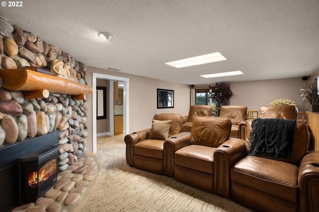 carpeted home theater featuring a fireplace, a textured ceiling, a wood stove, and a skylight