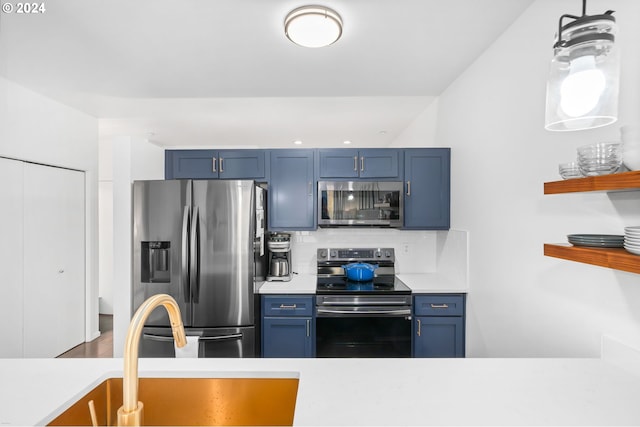 1125 NW 9th Ave Unit 419, Portland, OR 97209 - kitchen featuring stainless steel appliances, blue cabinets, light countertops, and backsplash