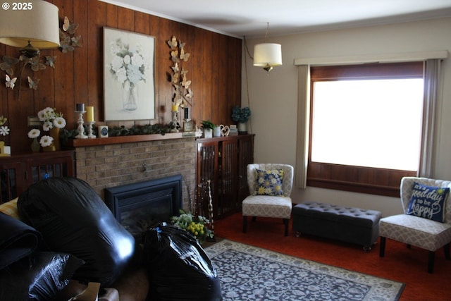 living room featuring wood walls, a brick fireplace, and ornamental molding