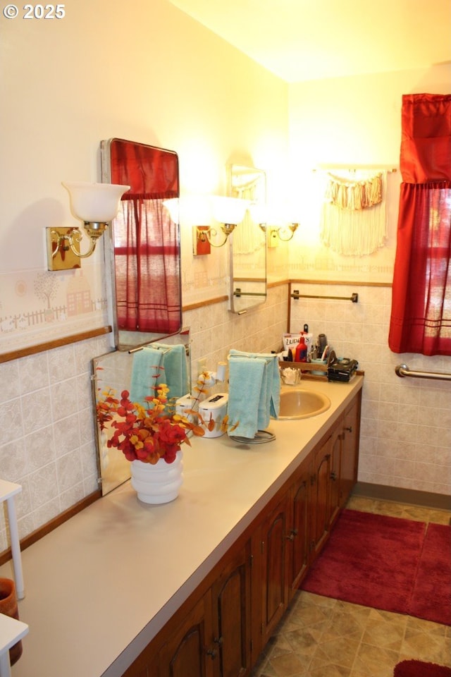 bathroom featuring vanity, wainscoting, and tile walls
