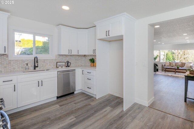 kitchen with sink, white cabinets, dishwasher, and light hardwood / wood-style flooring