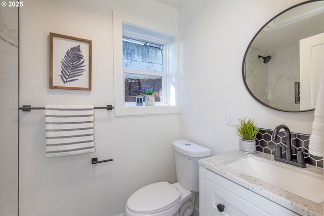 bathroom featuring toilet, a shower, and vanity