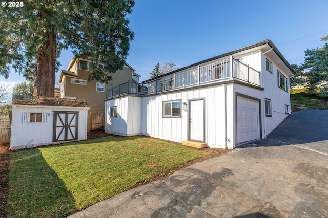 exterior space with a yard, a balcony, a garage, and a shed