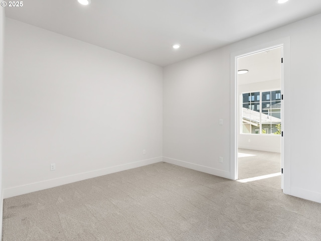 carpeted empty room featuring baseboards and recessed lighting