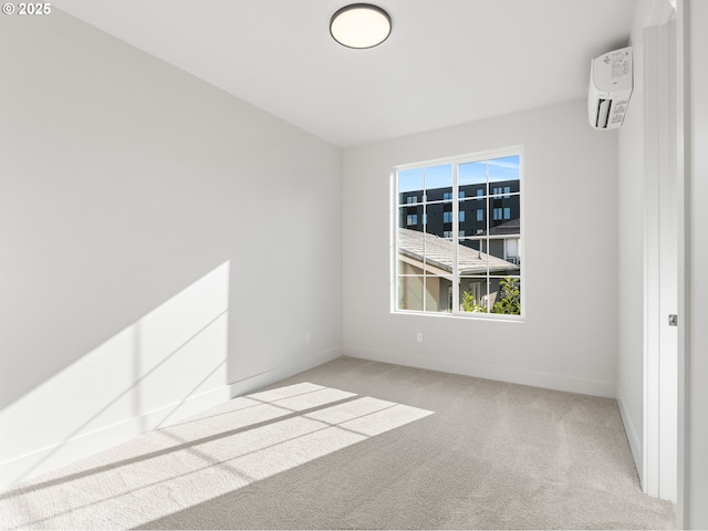 spare room featuring a wall mounted AC, carpet flooring, and baseboards