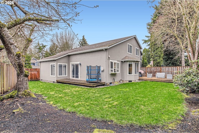 back of house with a fenced backyard, a yard, and a deck