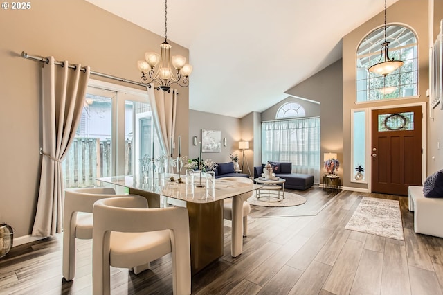 dining area with a notable chandelier, baseboards, high vaulted ceiling, and wood finished floors