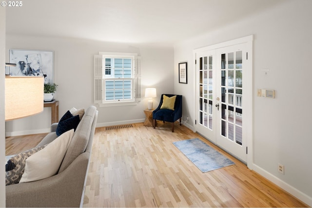 living area featuring light hardwood / wood-style flooring and french doors