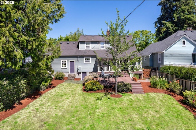 back of house featuring a wooden deck and a yard