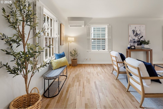 office space with an AC wall unit and light wood-type flooring