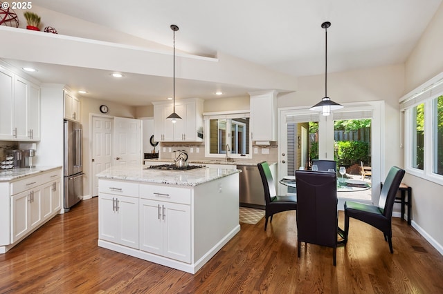 11315 NW Reeves St, Portland, OR 97229 - kitchen with stainless steel appliances, decorative backsplash, a kitchen island, dark wood finished floors, and white cabinets