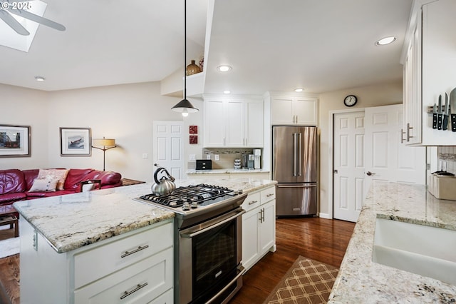 11315 NW Reeves St, Portland, OR 97229 - kitchen featuring stainless steel appliances, white cabinetry, dark wood-style floors, recessed lighting, and light stone counters