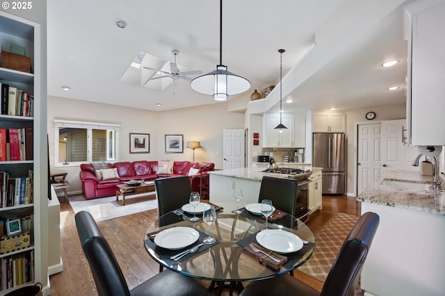 11315 NW Reeves St, Portland, OR 97229 - dining room featuring ceiling fan, dark wood-style floors, a skylight, and recessed lighting
