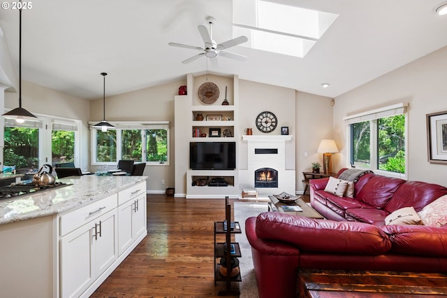11315 NW Reeves St, Portland, OR 97229 - living area with vaulted ceiling, plenty of natural light, a ceiling fan, dark wood-style flooring, and a lit fireplace