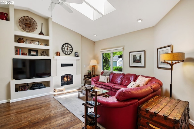 11315 NW Reeves St, Portland, OR 97229 - living area with vaulted ceiling, ceiling fan, wood finished floors, a lit fireplace, and built in shelves
