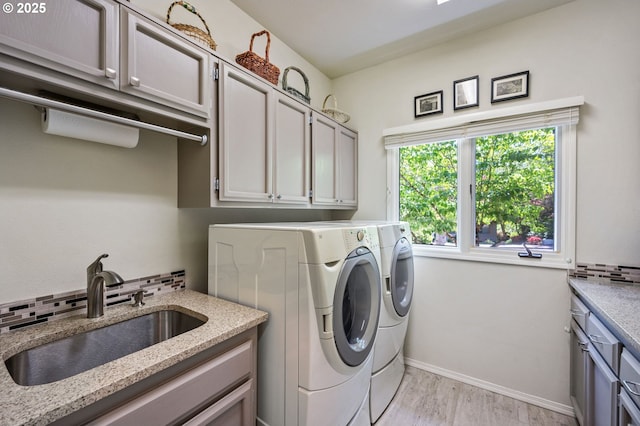 11315 NW Reeves St, Portland, OR 97229 - laundry area with cabinet space, separate washer and dryer, light wood-type flooring, and baseboards