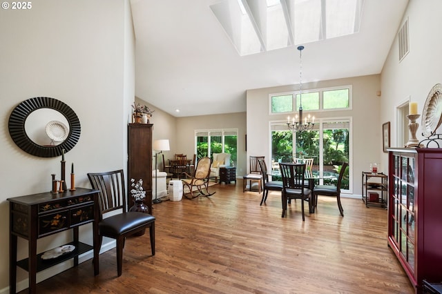 11315 NW Reeves St, Portland, OR 97229 - dining space with high vaulted ceiling, a chandelier, wood finished floors, and a skylight