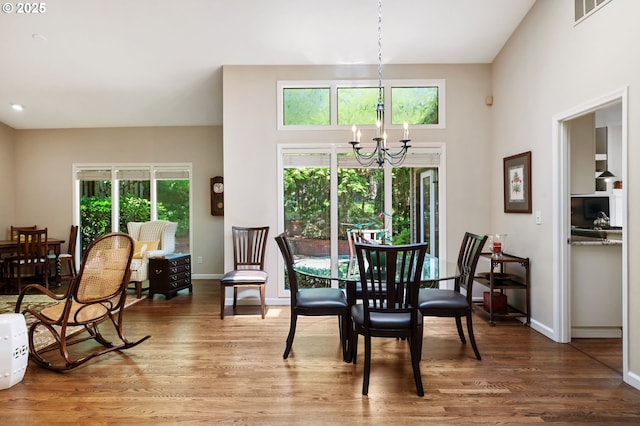 11315 NW Reeves St, Portland, OR 97229 - dining room featuring a chandelier, wood finished floors, baseboards, and a high ceiling