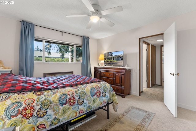 bedroom featuring a textured ceiling, ceiling fan, baseboards, and light colored carpet