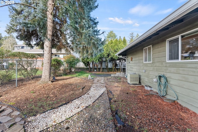 view of yard featuring fence and central AC unit