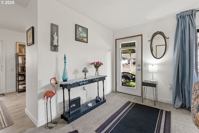 interior space featuring a textured ceiling and baseboards