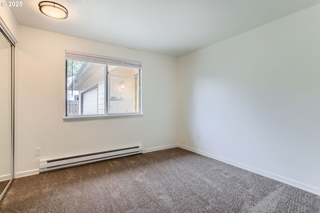 spare room with carpet floors, baseboards, and a baseboard heating unit