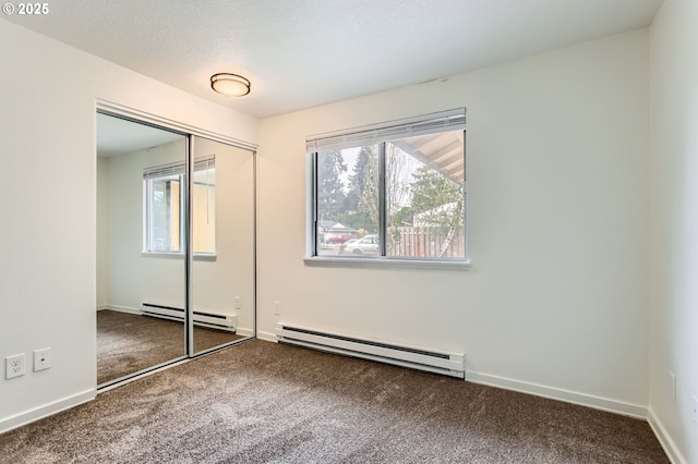 unfurnished bedroom featuring a baseboard radiator, carpet, and multiple windows