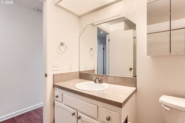 bathroom featuring vanity, wood finished floors, and toilet