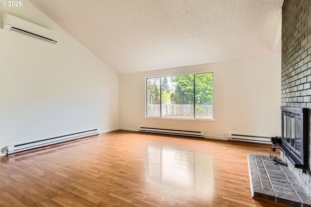 unfurnished living room with a baseboard heating unit, a wall mounted AC, and vaulted ceiling