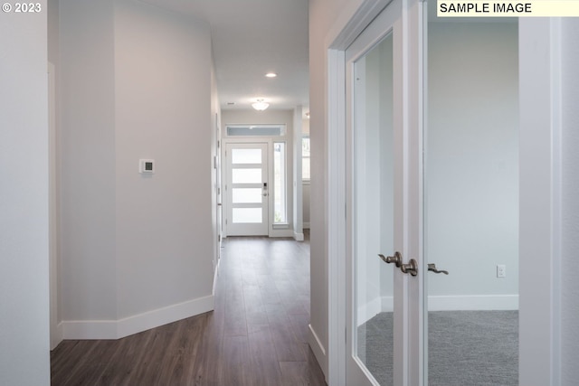 hallway with dark colored carpet