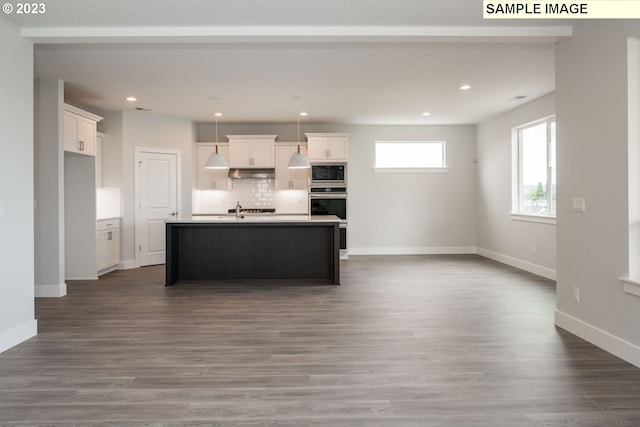 kitchen featuring white cabinets, an island with sink, appliances with stainless steel finishes, and dark hardwood / wood-style flooring