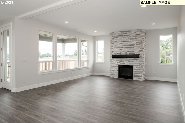 unfurnished living room featuring dark wood-type flooring and a fireplace