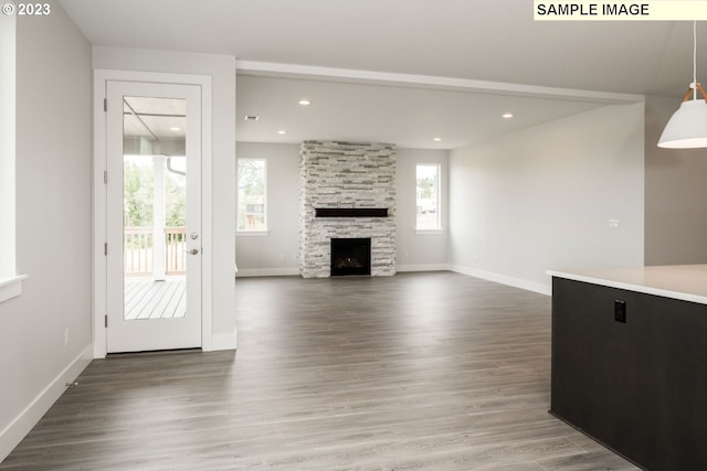 unfurnished living room featuring a stone fireplace and hardwood / wood-style flooring