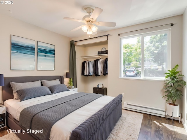47 Eagle Crest Dr Unit 22, Lake Oswego, OR 97035 - bedroom featuring a baseboard heating unit, wood finished floors, a closet, and a ceiling fan