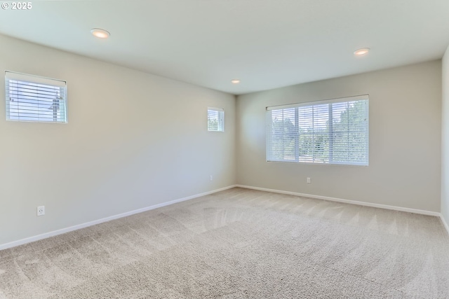 carpeted spare room featuring recessed lighting and baseboards