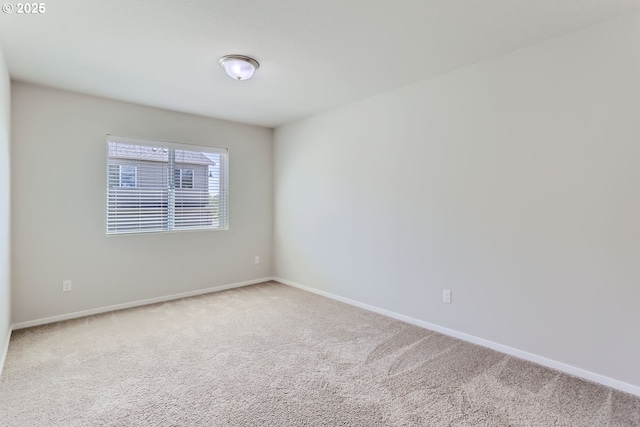 carpeted empty room featuring baseboards