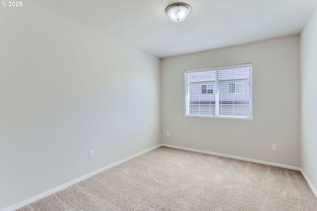 carpeted empty room with baseboards