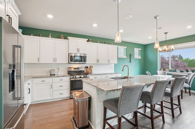 2570 SE Kane Ave, Gresham, OR 97080 - kitchen featuring stainless steel appliances, a sink, light wood finished floors, white cabinets, and recessed lighting