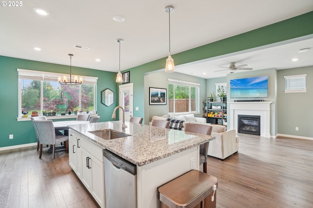 2570 SE Kane Ave, Gresham, OR 97080 - kitchen featuring dishwasher, a sink, white cabinets, a glass covered fireplace, and wood finished floors