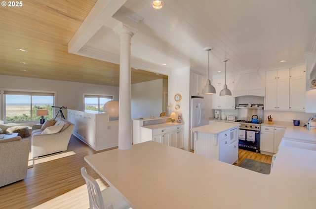 4830 Butterfly Ln, Gearhart, OR 97138 - kitchen with high end range, ornate columns, open floor plan, a sink, and wooden ceiling