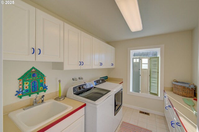 4830 Butterfly Ln, Gearhart, OR 97138 - washroom featuring cabinet space, independent washer and dryer, light tile patterned floors, and baseboards