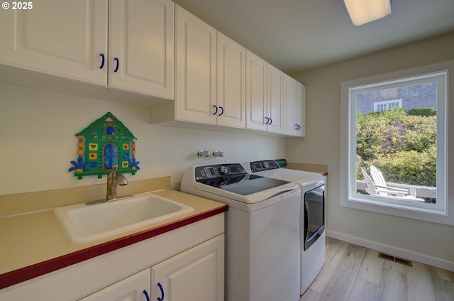 4830 Butterfly Ln, Gearhart, OR 97138 - washroom featuring washer and dryer, cabinet space, light wood-type flooring, and baseboards