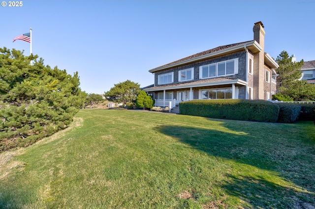 4830 Butterfly Ln, Gearhart, OR 97138 - view of property exterior featuring a chimney, a yard, and a porch