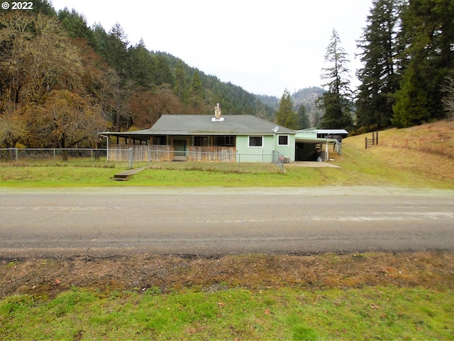 view of front of property featuring a carport, a mountain view, and a front yard