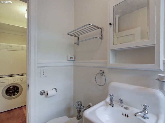 20 NW 16th Ave Unit 211, Portland, OR 97209 - half bath featuring stacked washer / drying machine and wood finished floors