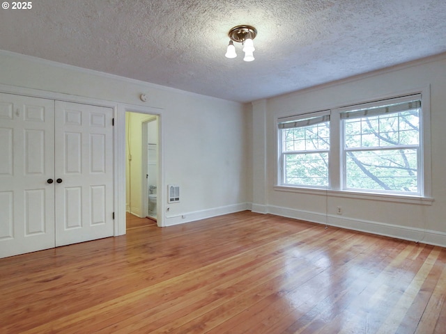 20 NW 16th Ave Unit 211, Portland, OR 97209 - unfurnished bedroom with a textured ceiling, light wood-style flooring, baseboards, and a closet