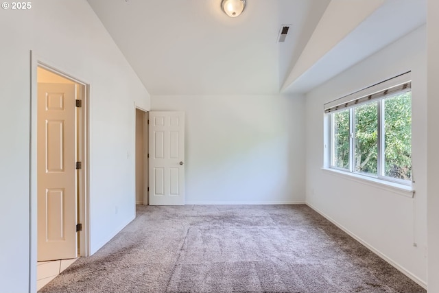 spare room with vaulted ceiling and light carpet