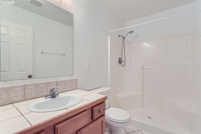 bathroom featuring a shower, vanity, and toilet