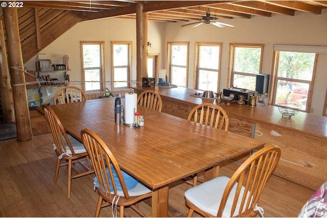 dining space featuring vaulted ceiling with beams, hardwood / wood-style flooring, and a wealth of natural light